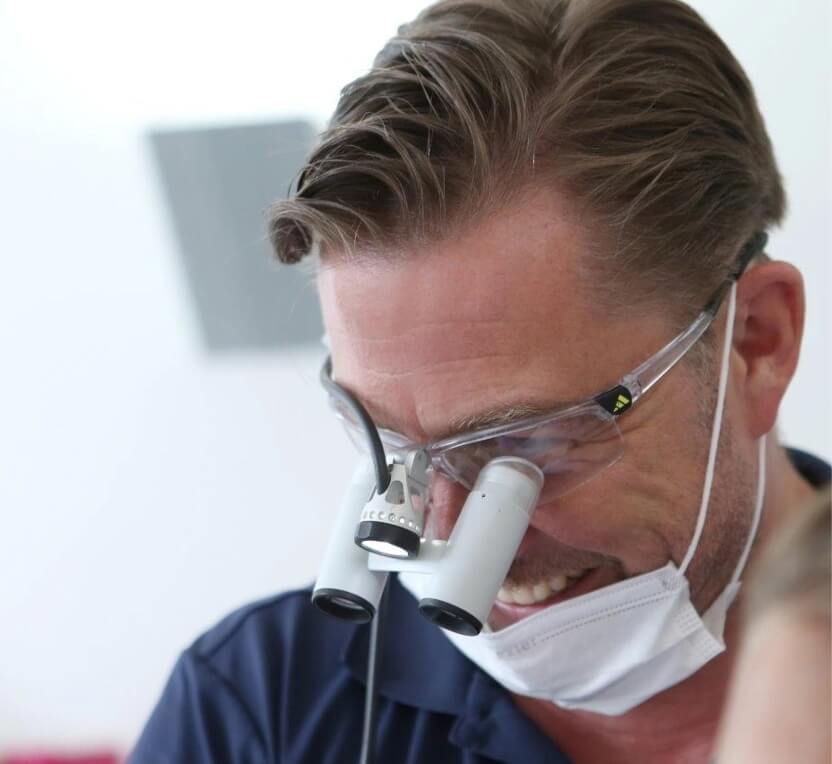 Dr. Gottschlich mit Lupenbrille bei einer zahnmedizinischen Behandlung